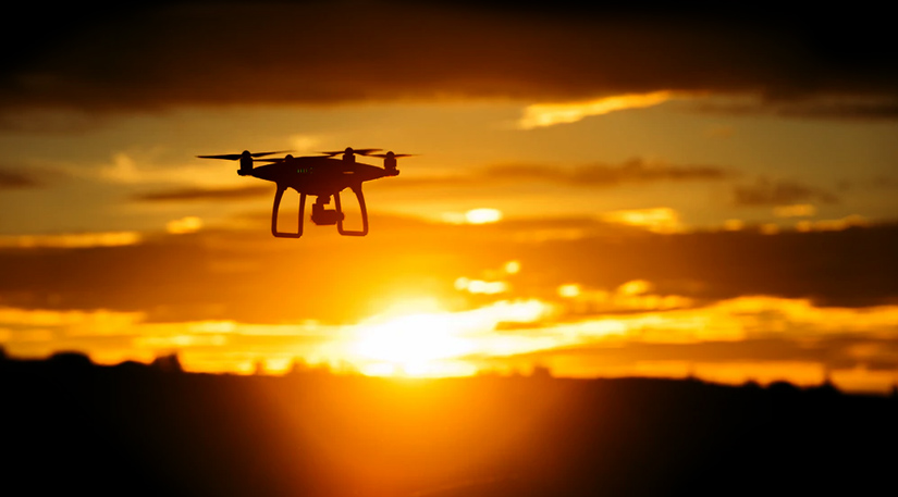 A drone flying into the sunset