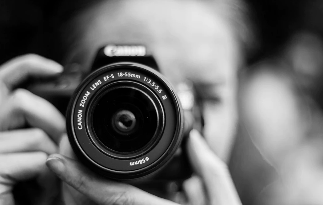 A close up shot of a woman with an SLR camera