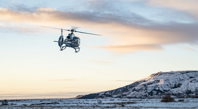 A helicopter flying over an icy tundra
